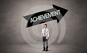 Young business person in casual holding road sign