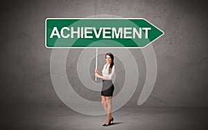 Young business person in casual holding road sign