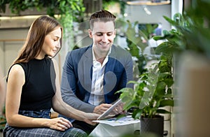 Young Business Persons Having Discussion While Holding Digital Tablet Sitting At Cafe.