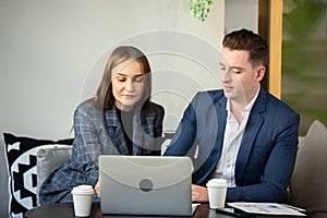 Young Business Persons Having Discussion While Holding Digital Tablet Sitting At Cafe.