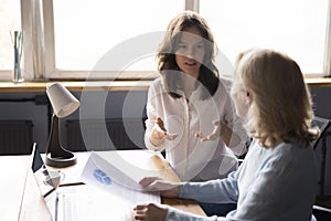 Young business professional woman discussing paper marketing report