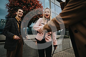 Young business professionals shaking hands outside an office building