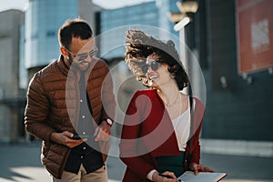 Young business professionals with tablet in urban setting discussing growth strategies