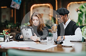 Young business professionals working on a project together at a cozy cafe.