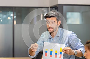 Young business team of coworkers meeting in creative office, businessman holding paper and sitting on table, Teamwork concept