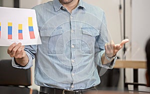 Young business team of coworkers meeting in creative office, businessman standing and holding paper in meeting room, Teamwork