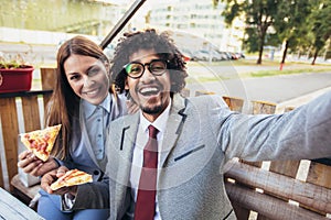 Young business team eating pizza in outdoor cafe make selfie photo.Business,food and people concept