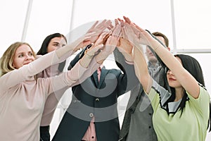 Young business team joining their hands over the Desk