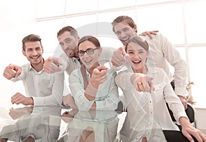 Young business team pointing at you