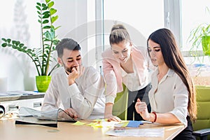 Young business team reading sticky notes on the work desk in office. Business, teamwork, brainstorming concept.