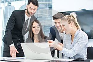 Young business team working together in the office. Businesswoman pointing to laptop screen