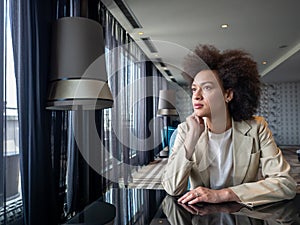 Young business woman with afro hairstyle smiling in urban background