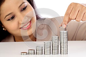 Young business woman arranging stack of coins - Money growth con