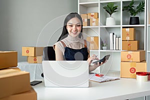 Young business woman asian working online ecommerce shopping at her shop. Young woman sell prepare parcel box of product