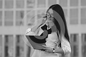 Young business woman on background of skyscraper. Black and whit