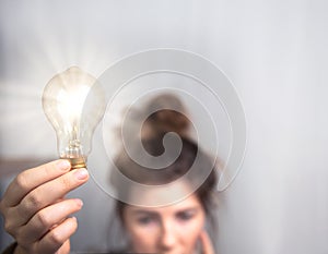 Young business woman brainstorming, creating ideas,education,learning concept with shining light bulb and copy space