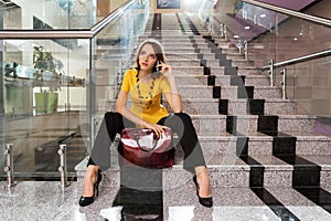 Young fashion business woman calling on phone in office