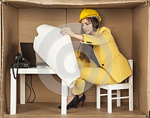 Young business woman carefully reading building plans