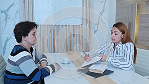 Young business woman chatting to intern discussing job interview colleagues having conversation in office enjoying