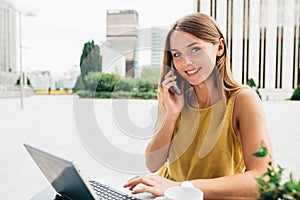 Young business woman on the computer and on the mobile phone
