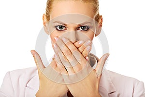 Young business woman covering her mouth with two hands