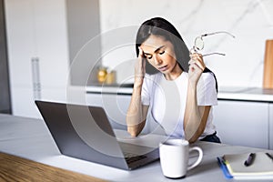 Young business woman in depression working on laptop at home