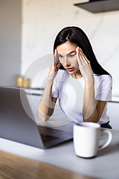 Young business woman in depression working on laptop at home