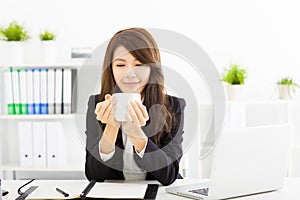 young business woman drinking coffee in office