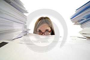 Young business woman drowning in paperwork