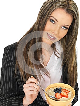 Young Business Woman Eating a Bowl of Porridge with Fresh Fruit