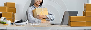 Young business woman entrepreneur is smiling and holding parcel box