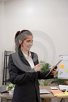 Young business woman executive worker holding digital tablet using pad technology device working in office