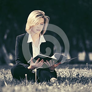 Young business woman with file folder in city park