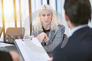 Young business woman focused eyes confident talk to your boss attentively in office meeting room for job interview