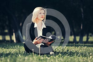 Young business woman with a folder in city park