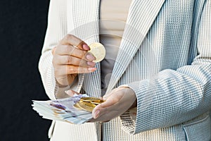 Young business woman holding British pounds and bitcoin in hands, close up of female hands with cash equivalents