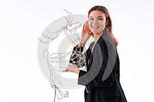 Young business woman holding illuminated Christmas deer decor dressed black suit isolated on white background