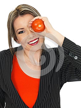 Young Business Woman Holding a Raw Tomato over her Eye photo