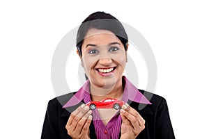 Young business woman holding toy car