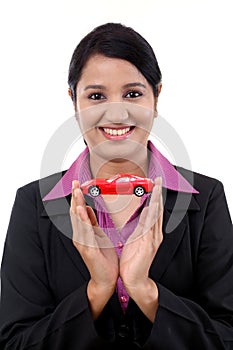Young business woman holding toy car