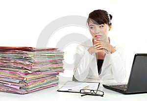 Young business woman with laptop and many paper