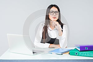 Young business woman on a laptop at working desk isolated on white background