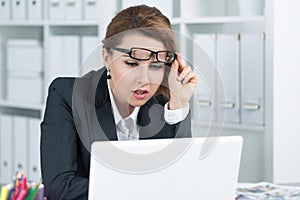 Young business woman looking intently at laptop photo