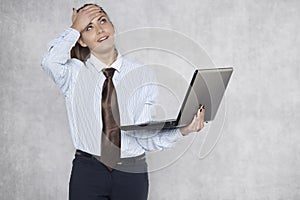 Young business woman looks in disbelief at a laptop screen