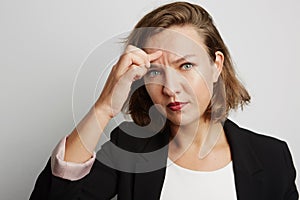 Young business woman made a mistake, studio photo on a white background.