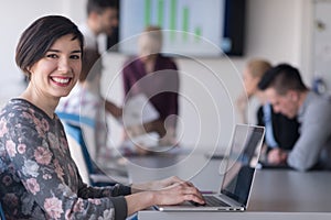 Young business woman at office working on laptop with team on me