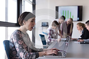 Young business woman at office working on laptop with team on me