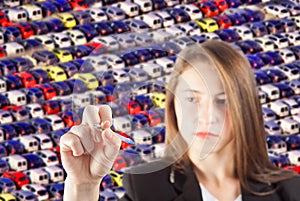 Young business woman with pen in hand and many cars blurred in background