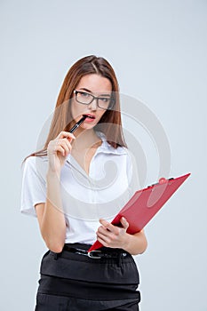 The young business woman with pen and tablet for notes on gray background