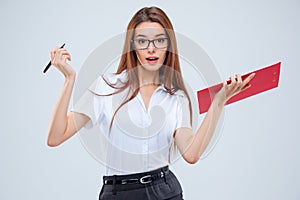 The young business woman with pen and tablet for notes on gray background